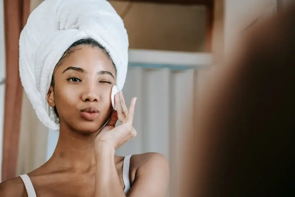 Woman applying skincare at home after shower for a healthy, glowing skin routine